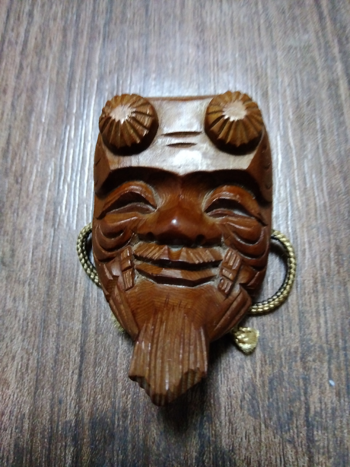 Noh mask netsuke by Akiyuki Matsuda. Hida Takayama Ichii Itto-bori carving. Strap. Noh mask netsuke have been popular among common people as a charm against evil. Itto-bori carving is a prestigious craft that has continued since the Edo period.